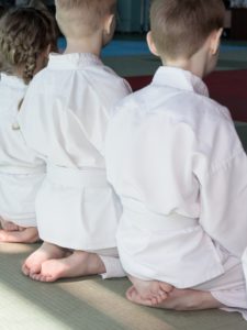 children sitting in martial arts school training